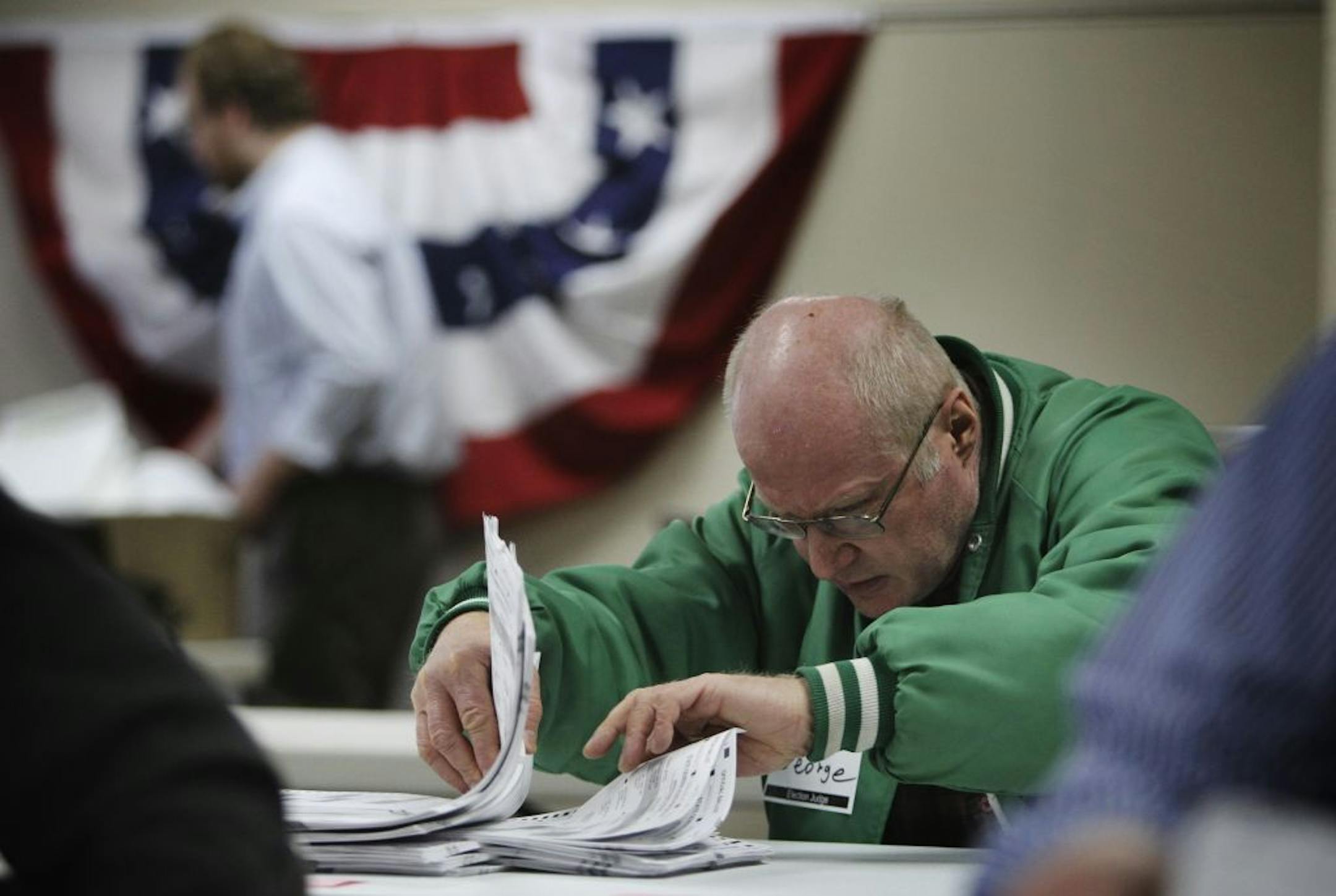 Election judge George Kosa orientated ballots that were to be hand-counted Wednesday at the Minneapolis elections warehouse. Results are expected to be delivered to the secretary of state by Thursday.