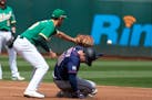 Minnesota Twins' Brett Rooker slides into second base before the tag of Oakland Athletics first baseman Matt Olson (28) during the second inning