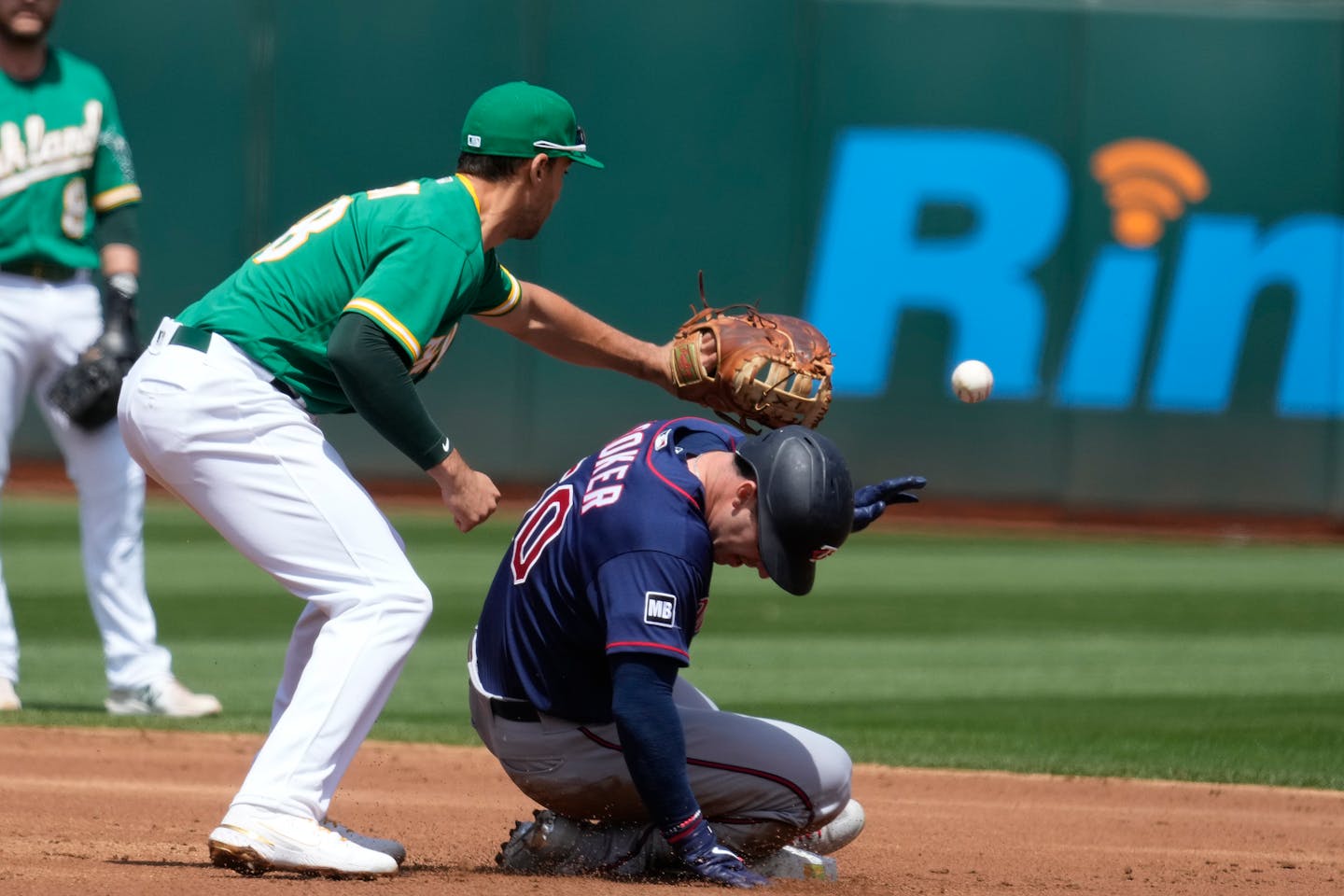 Minnesota Twins' Brett Rooker slides into second base before the tag of Oakland Athletics first baseman Matt Olson (28) during the second inning