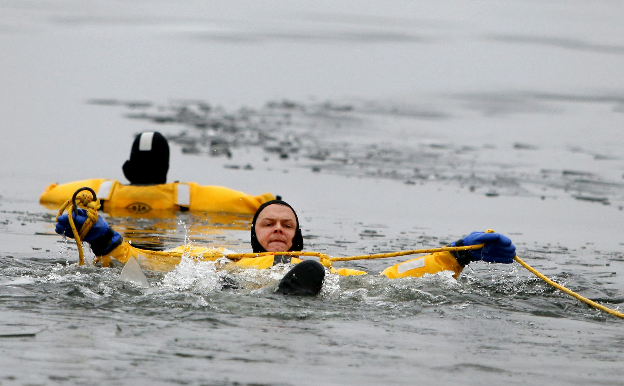 Hennepin County Sheriff Rich Stanek held a press conference on the dangers of thin ice for this holiday season. Members of the department showed off cold water emergency rescue equipment and also demonstrated an icy water rescue. Stanek said ice is not safe for anyone to walk on nor for any vehicles or recreational equipment. Until further notice, Stanek advised everyone to stay off area lakes. Here, during a mock ice rescue, Hennepin County Sheriff's deputy Jeremy Gunia, left, is stuck in the l