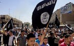 FILE - In this June 16, 2014 file photo, demonstrators chant pro-Islamic State group, slogans as they carry the group's flags in front of the provinci
