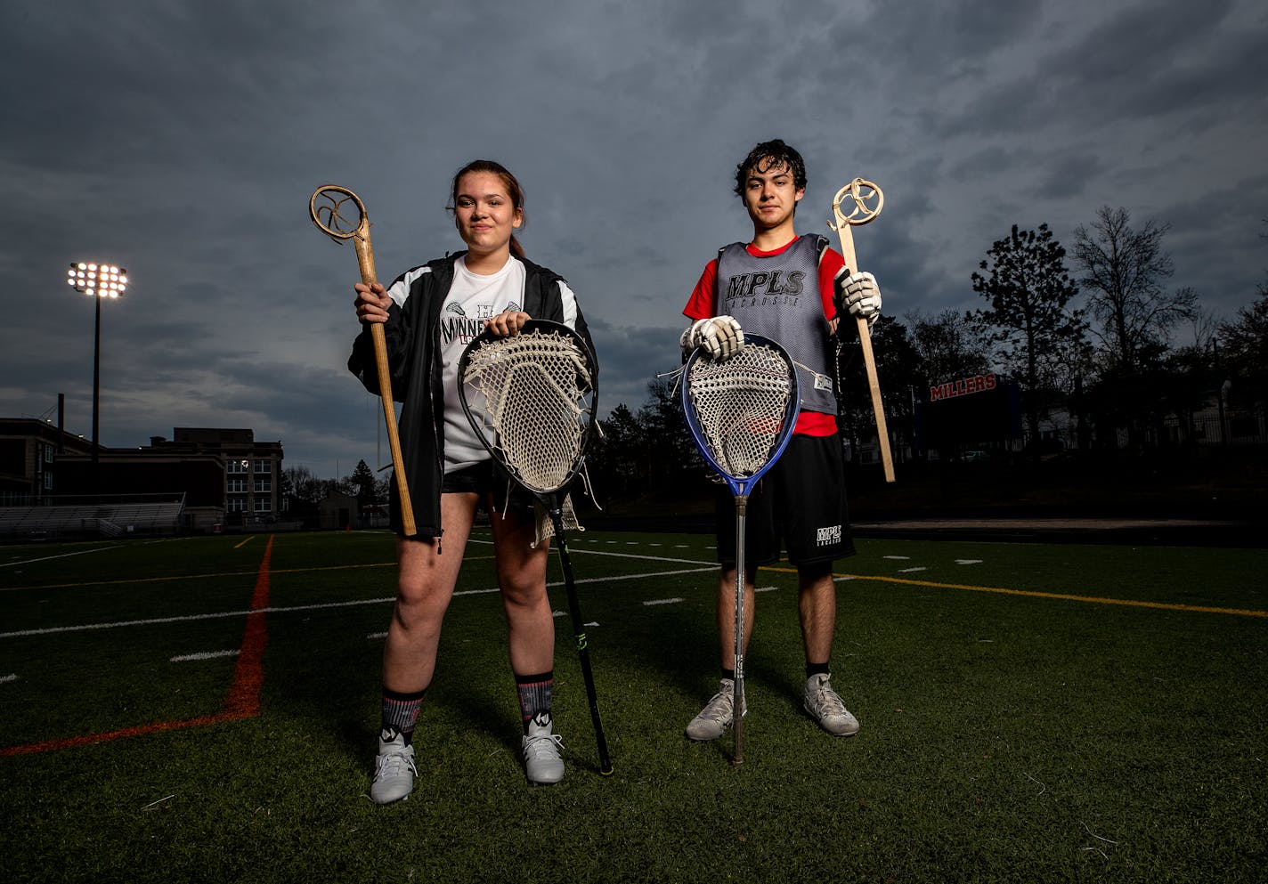 Tillie Turner and Chaska Spears share an interest in their cultural ties to lacrosse, a sport with centuries-old roots in North America. The two are holding both their regular sticks and their sticks for the traditional version of their sport.