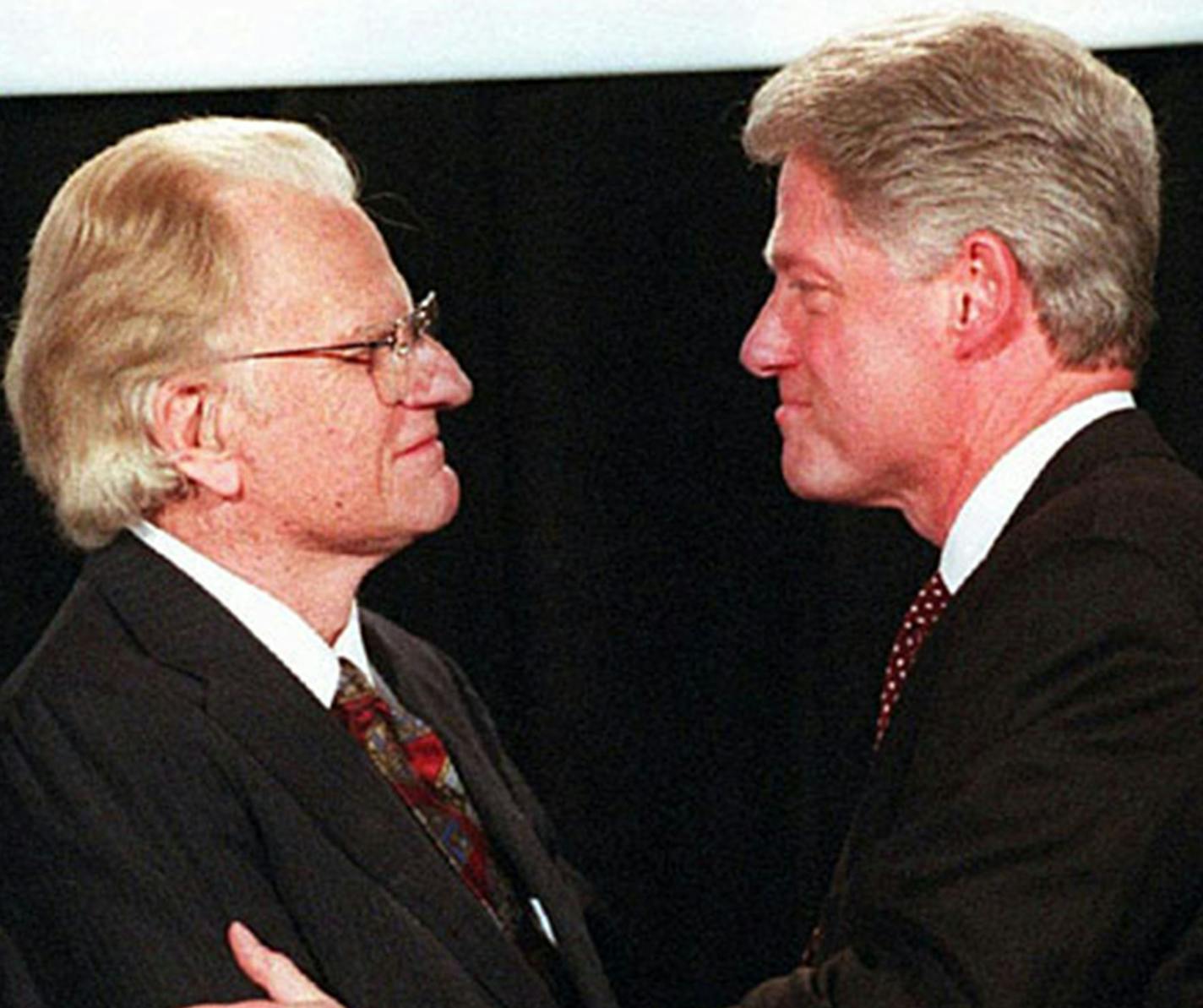 Billy Graham and President Bill Clinton talk before Graham's address on May 2, 1996. (Gary O'Brien/Charlotte Observer/TNS)