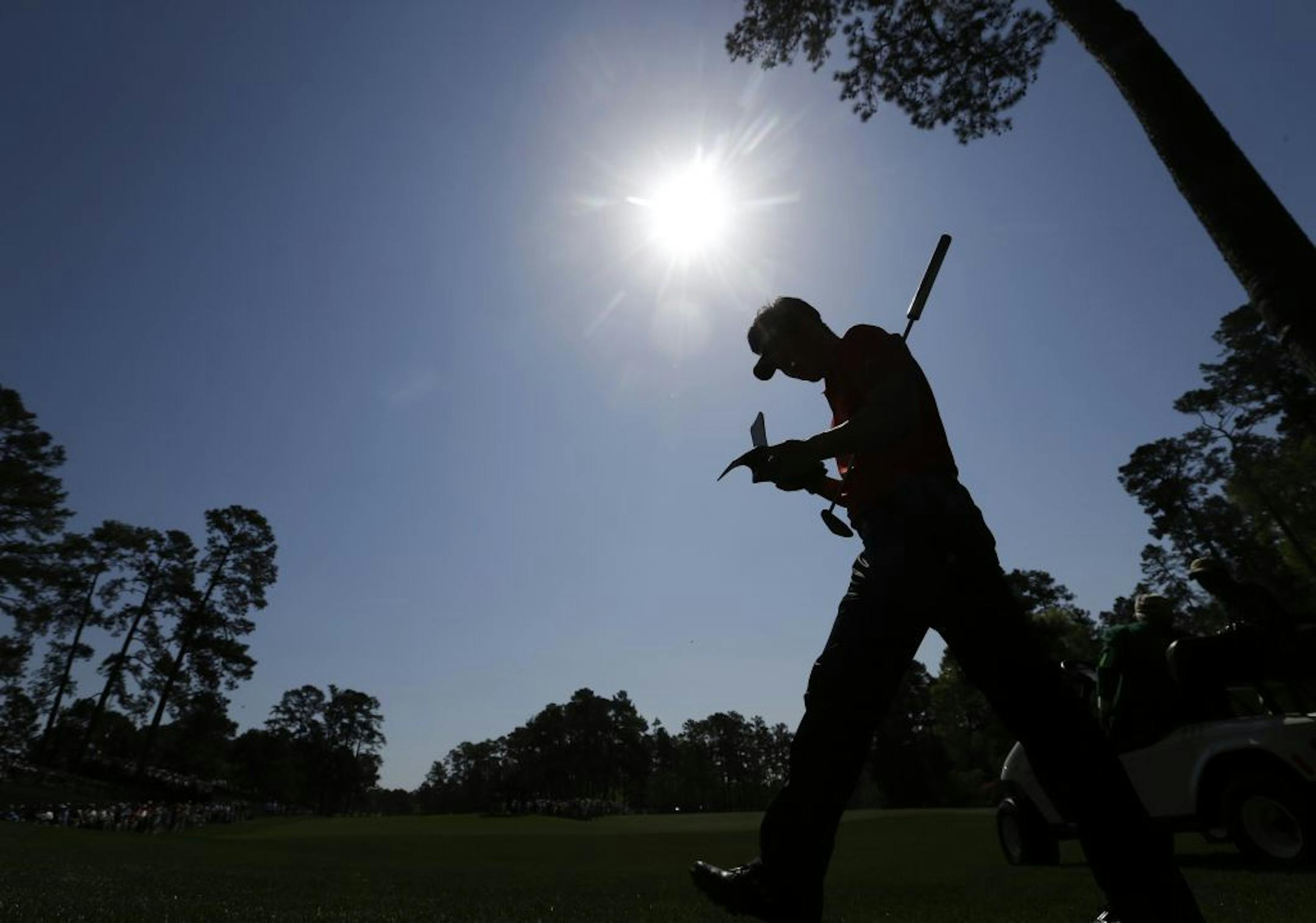 Y.E. Yang, of South Korea, is silhouetted agains the sunlight as he walks to the 14th tee during a practice round for the Masters golf tournament Tuesday, April 9, 2013, in Augusta, Ga.