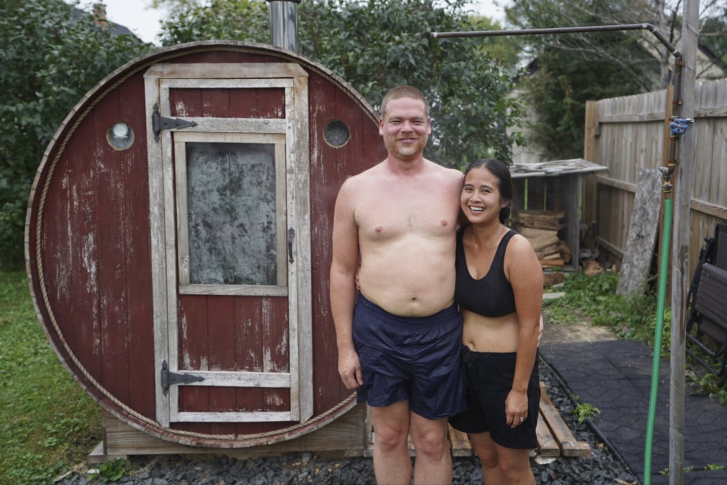 Christopher and Julie Rice outside the barrel sauna in their neighbor's backyard.