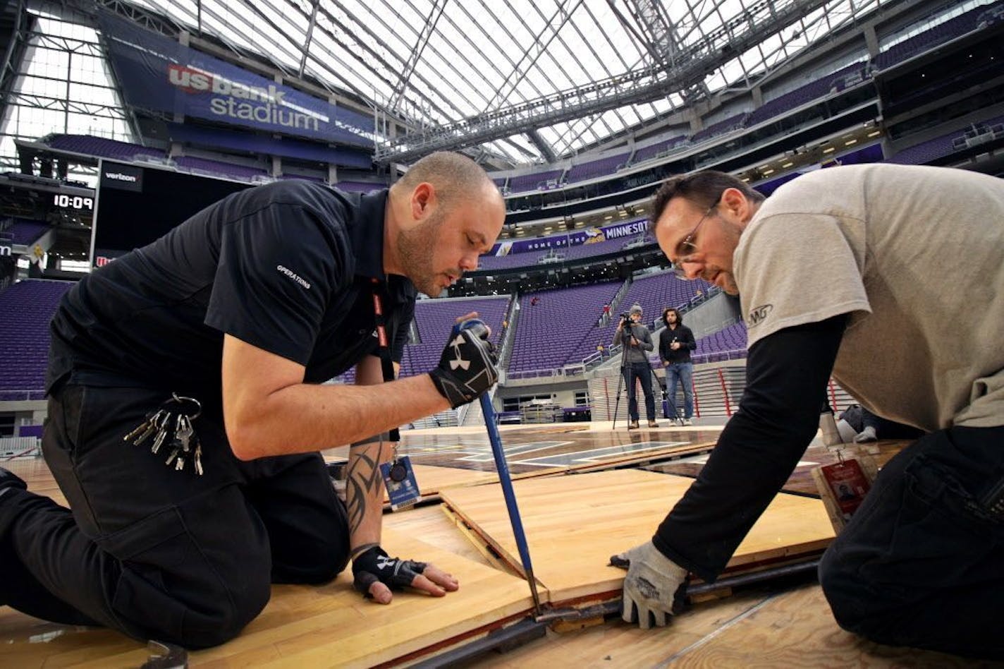 Preparations are underway for the U.S. Bank Stadium Basketball Classic, the venue's first basketball event. Here, Ricky Gieser and Michael Stauffacher help lay the basketball court floor Tuesday morning.