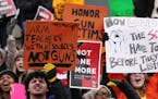 Students holding signs protesting gun violence, including Chris Vazquez, 17, of Fridley, left, gathered Saturday at the State Capitol for a rally. ] A