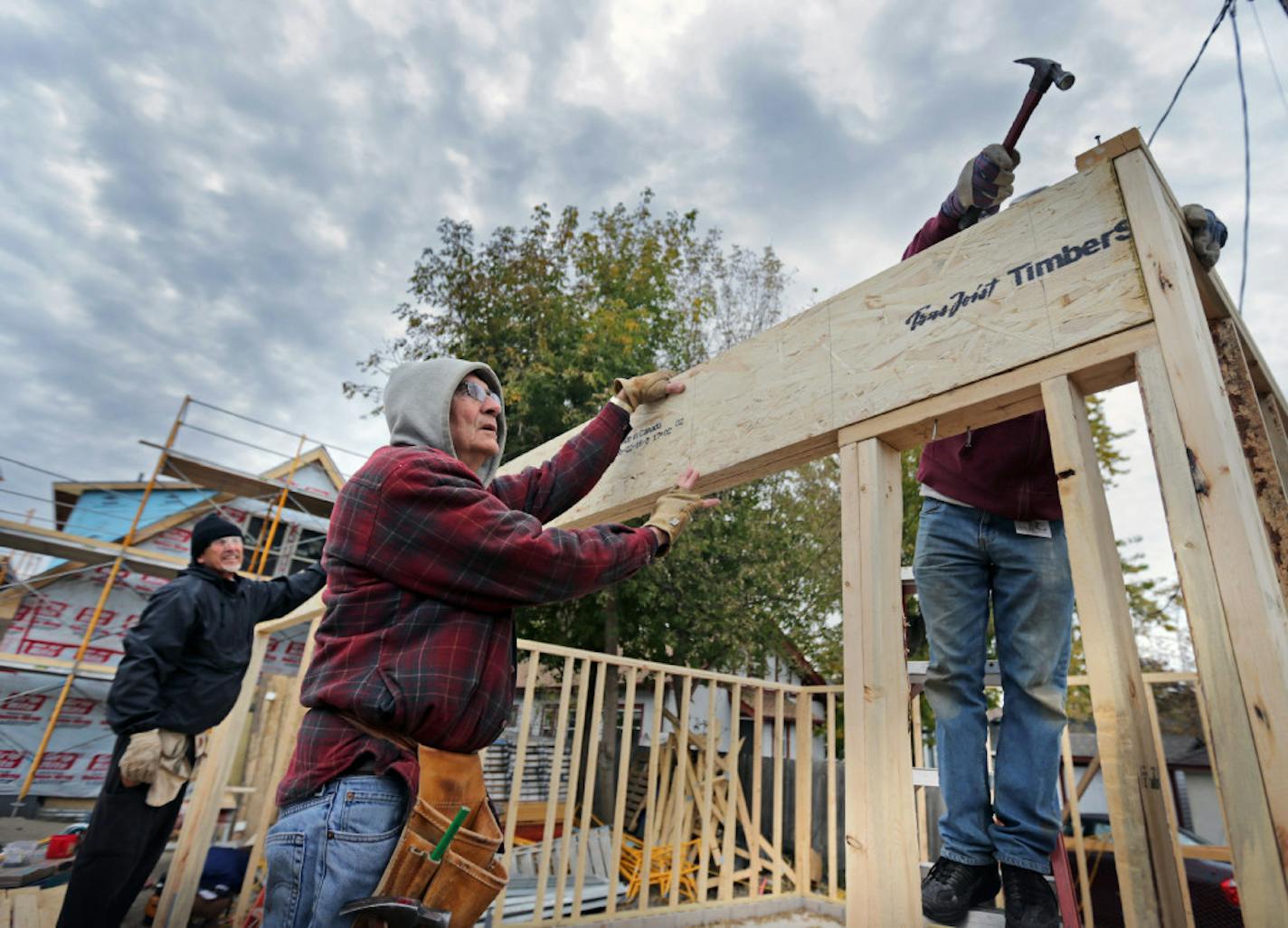 Habitat for Humanity volunteer Vince Kinney (center) worked on a new house garage at 2700 Morgan Av. N. in Minneapolis last month.