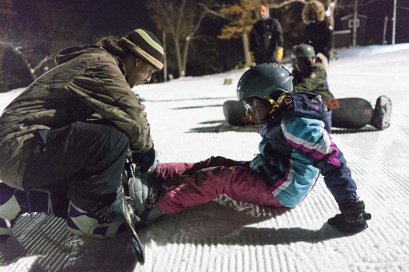 Pro snowboarder Jake Olson-Elm straps in Amourah Hammond, 8 at Theodore Wirth Park in Minneapolis on Thursday, Feb. 14 2019. ]
TONY SAUNDERS &#xb0; anthony.saunders@startribune.com Olson Elm and fellow pro snowboarder Joe Sexton partnered with Anthony Taylor, founder of the Loppet Foundation to create Cool Meets Cause to help kids have access to affordable snowboarding lessons.