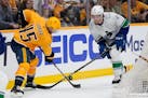 Nashville defenseman Alexandre Carrier battles Canucks right wing Brock Boeser for the puck during the third period in Game 6.