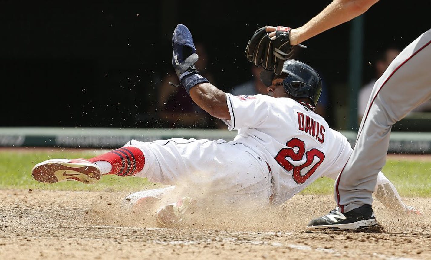 Cleveland Indians' Rajai Davis (20) scores on a wild pitch by Minnesota Twins relief pitcher Michael Tonkin (59) during the seventh inning of a baseball game Thursday, Aug. 4, 2016, in Cleveland.