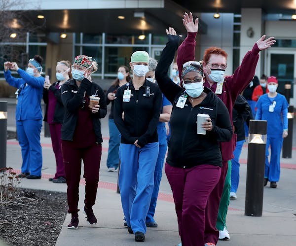Regions Hospital healthcare workers came outside Wednesday to thank Xcel Energy crew members who had gathered outside to greet and thank them during t