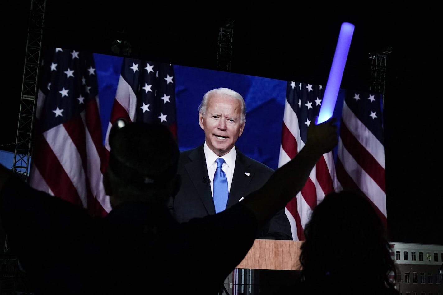 Supporters watch the program outside the venue where Democratic presidential candidate former Vice President Joe Biden is speaking, during the final day of the Democratic National Convention, Thursday, Aug. 20, 2020, at the Chase Center in Wilmington, Del. (AP Photo/Carolyn Kaster)