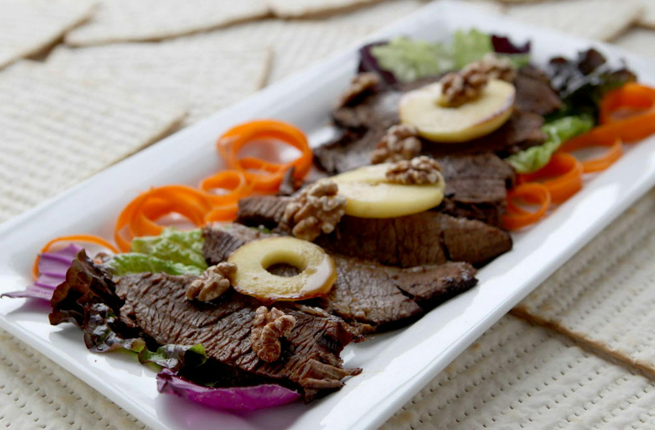 Brisket, charoset style, with apples and toasted walnuts, is a new variation on an old favorite for Passover seders. (Hillary Levin/St. Louis Post-Dispatch/TNS) ORG XMIT: 1183327