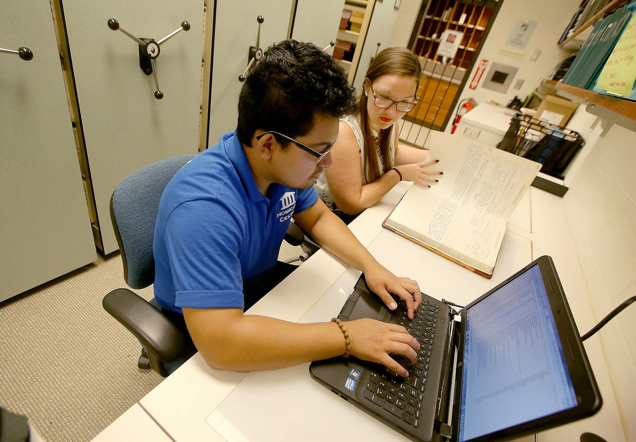 Leo Loza, left, a U of M student, and Hailey Johnson, a U of M graduate, worked on documenting information from a 1931 coroner report at the Hennepin County Medical Examiner's Office, Wednesday, July 27, 2016 in Minneapolis, MN. Researchers, who are all students, are getting a rare look into documents from the past 110 years, indexing the deaths for the Medical Examiner's Office and tracking homicide trends. ] (ELIZABETH FLORES/STAR TRIBUNE) ELIZABETH FLORES • eflores@startribune.com