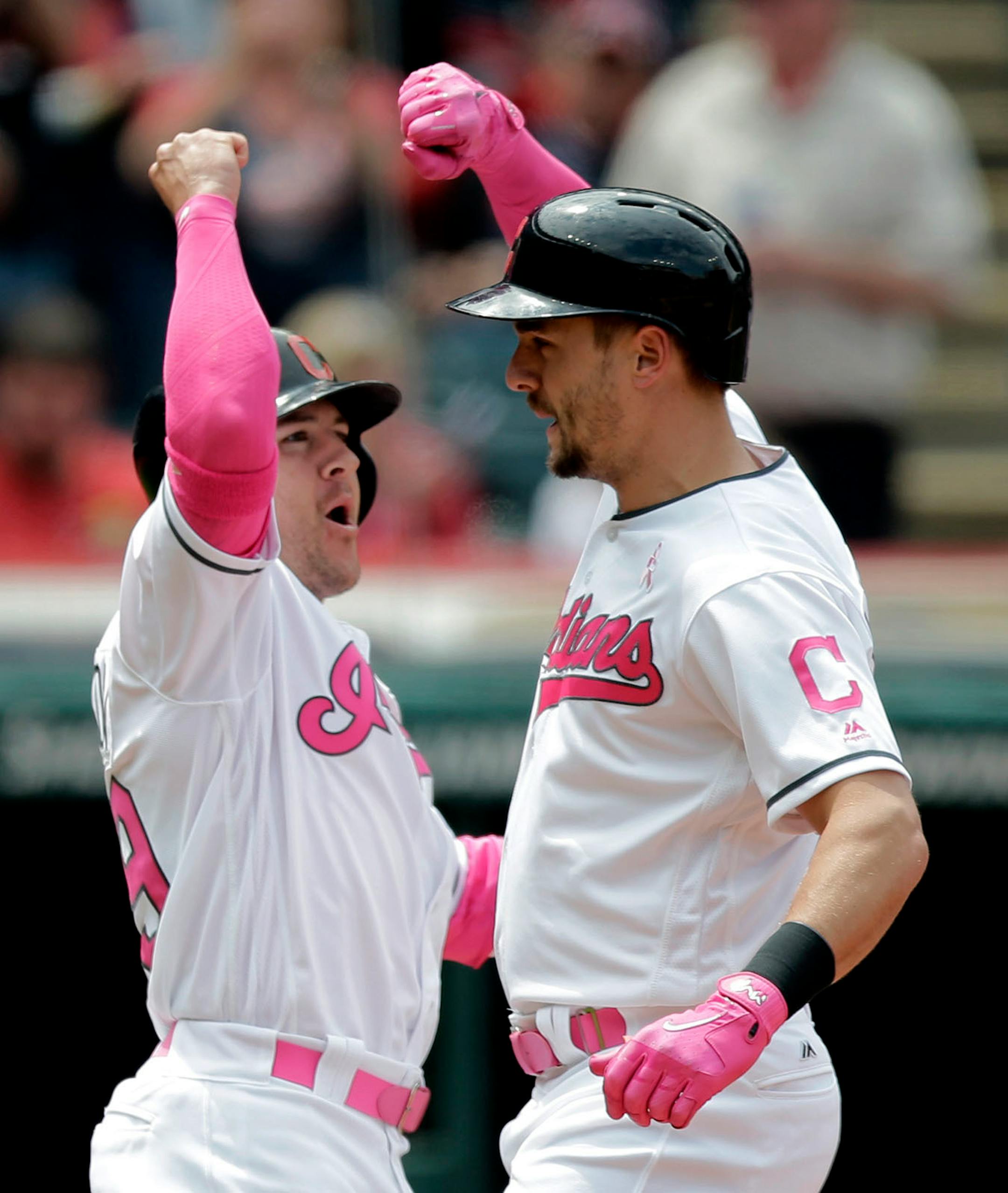 Cleveland Indians' Lonnie Chisenhall, right, and Daniel Robertson celebrate after they scored on Chisenhall's two-run home run off Minnesota Twins' Hector Santiago in the second inning of a baseball game, Sunday, May 14, 2017, in Cleveland.