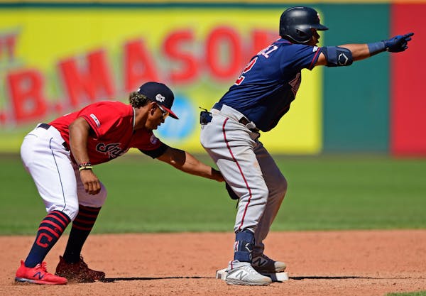 Luis Arraez, right, celebrates after hitting a double in the eighth inning of a baseball game against the Cleveland Indians, Sunday, July 14, 2019, in