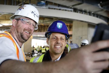 Carpenter Chad Canesi takes a selfie with Minnesota Vikings owner Mark Wilf during a free lunch for construction workers at the NFL football team's ne