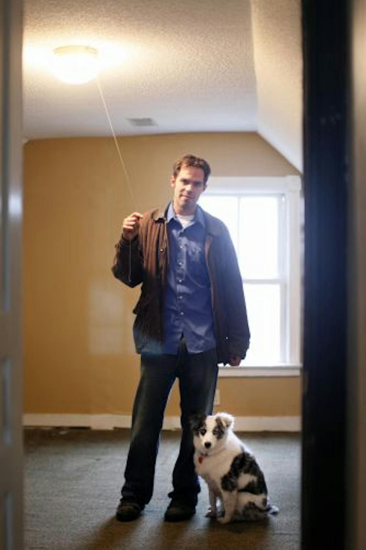 Andrew Dick, with his dog Sally, in one of the upstairs bedrooms of a house that he bought on St. Paul's East Side in November. The City Council will decide whether he will be able to keep the house and fix it up. The house has been slated for demolition.