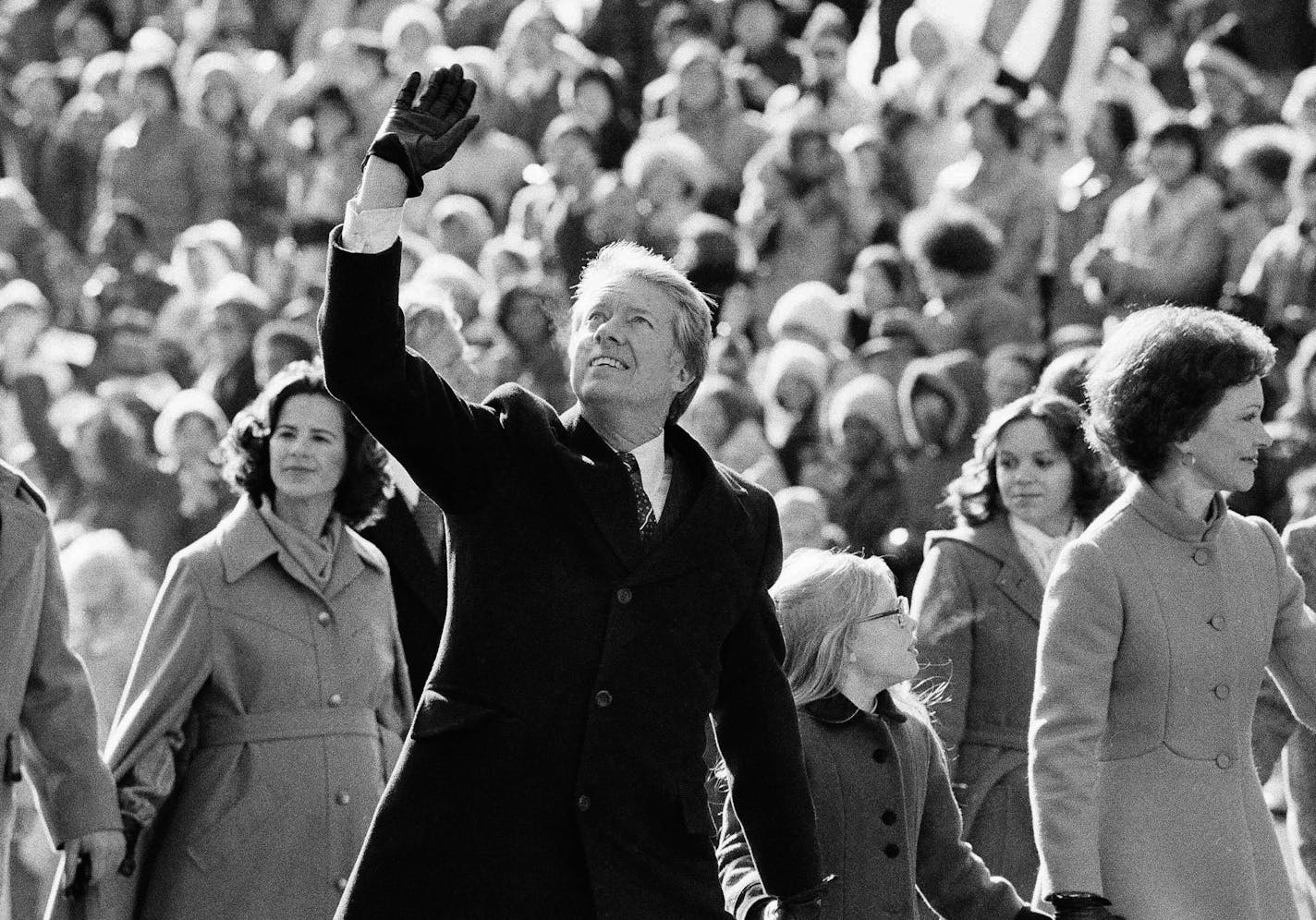 FILE - In this Thursday, Jan. 20, 1977 file photo, President Jimmy Carter waves to the crowd while walking with his wife, Rosalynn, and their daughter, Amy, along Pennsylvania Avenue from the Capitol to the White House following his inauguration in Washington.