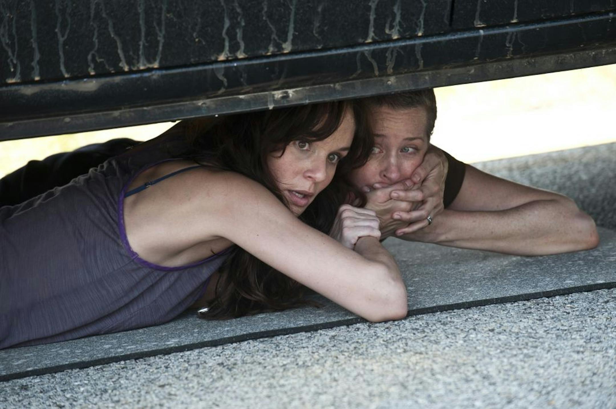 Lori Grimes (Sarah Wayne Callies) and Carol (Melissa Suzanne McBride) hide from zombies in a scene from the season premiere of "The Walking Dead."