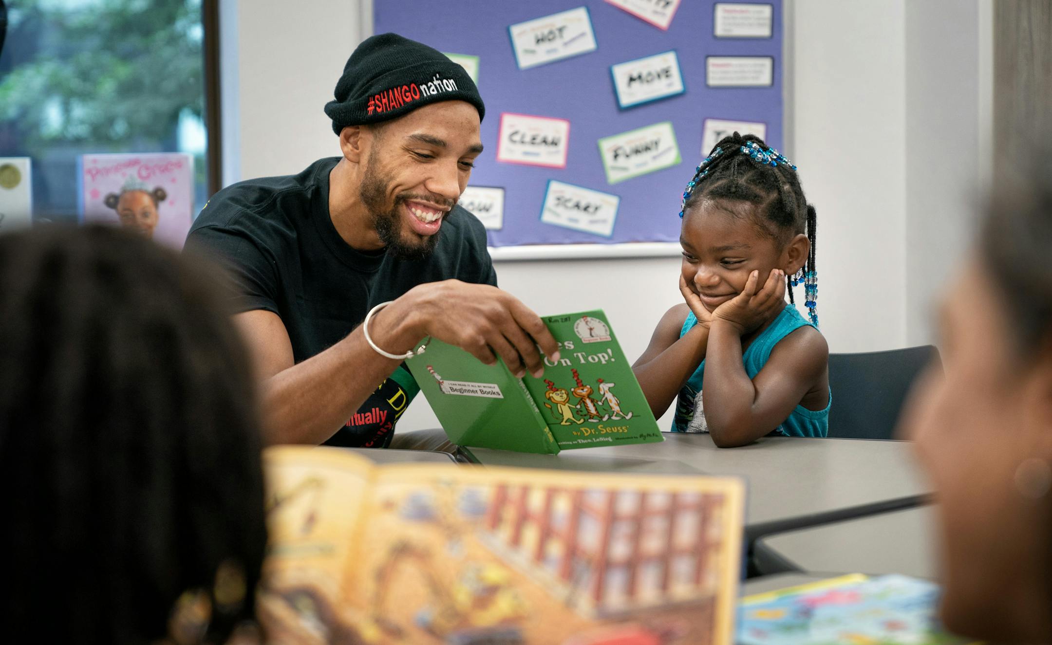 Boxer Jamal James got a smile out of Makilah Orr, 4, as he read Dr. Seuss to her at People Serving People in Minneapolis.