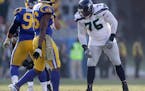 Seattle Seahawks offensive tackle Duane Brown, right, lines up against Los Angeles Rams defensive end Aaron Donald, left, and defensive end Dante Fowl