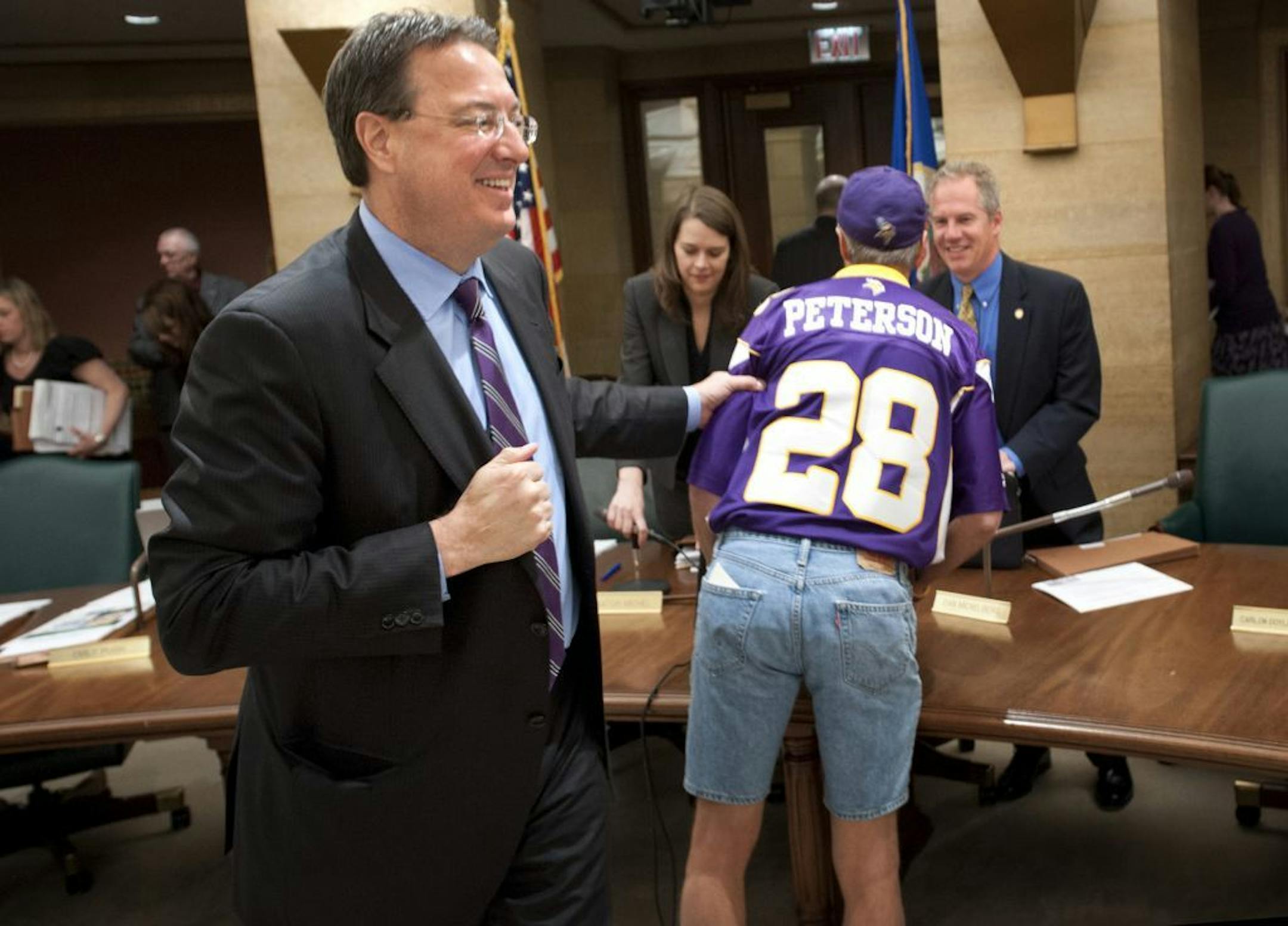 Vikings executive Lester Bagley grabbed "Superfan" Larry Spooner after the stadium bill was sent to the Senate Finance Committee.