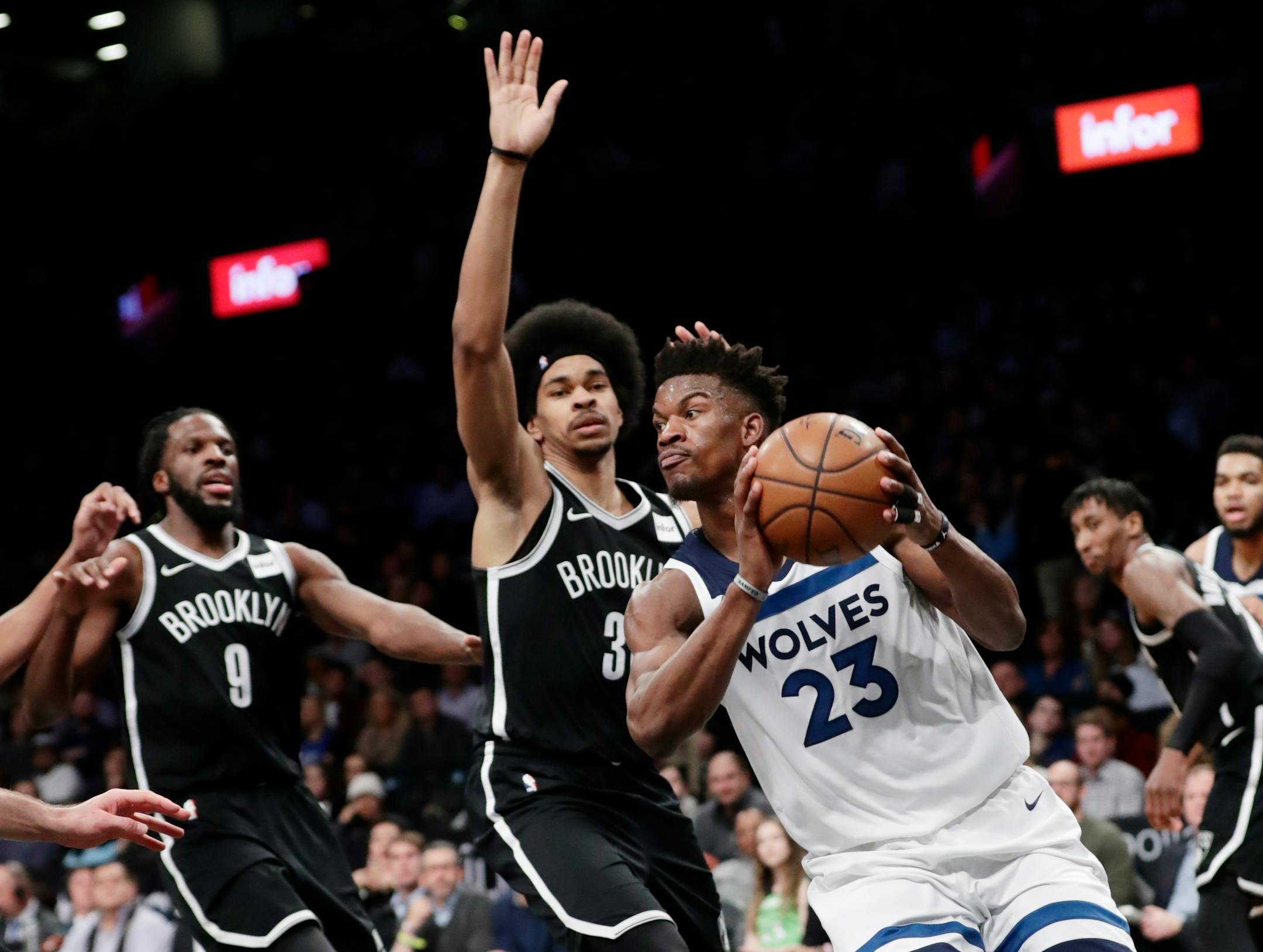 Minnesota Timberwolves' Jimmy Butler (23) looks to pass away from Brooklyn Nets' Jarrett Allen (31) and DeMarre Carroll (9) during the first half of an NBA basketball game Wednesday, Jan. 3, 2018, in New York. (AP Photo/Frank Franklin II)