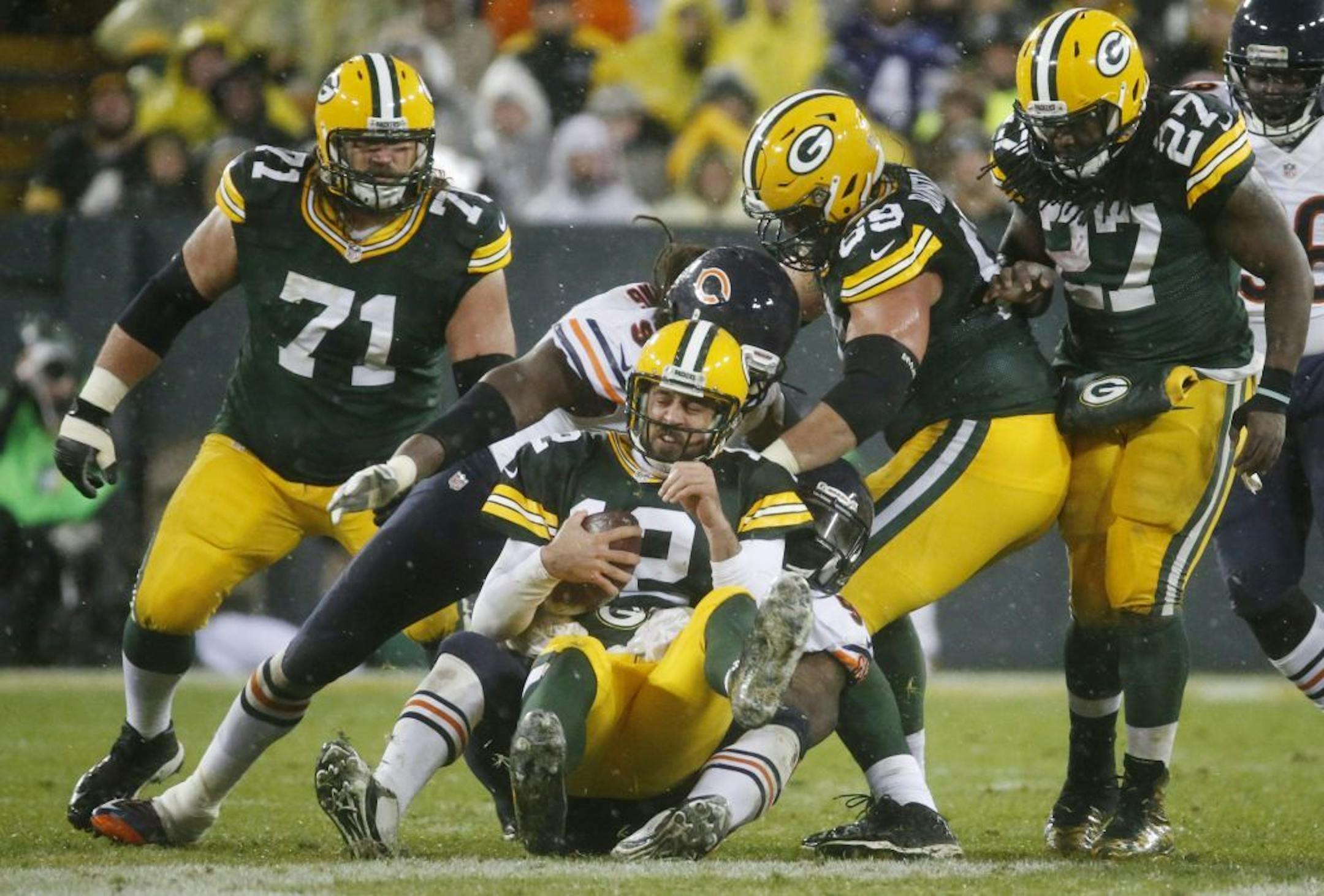 Green Bay Packers' Aaron Rodgers grimaces as he is tackled after recovering a fumble during the second half of an NFL football game against the Chicago Bears Thursday, Nov. 26, 2015, in Green Bay, Wis.