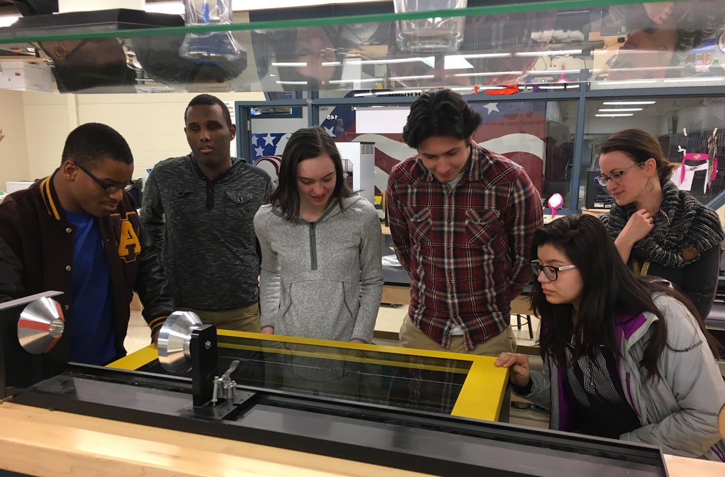 Apple Valley High School students work in groups on the laser engraver in the "Fab Lab" to create a prototype for BTM Global.