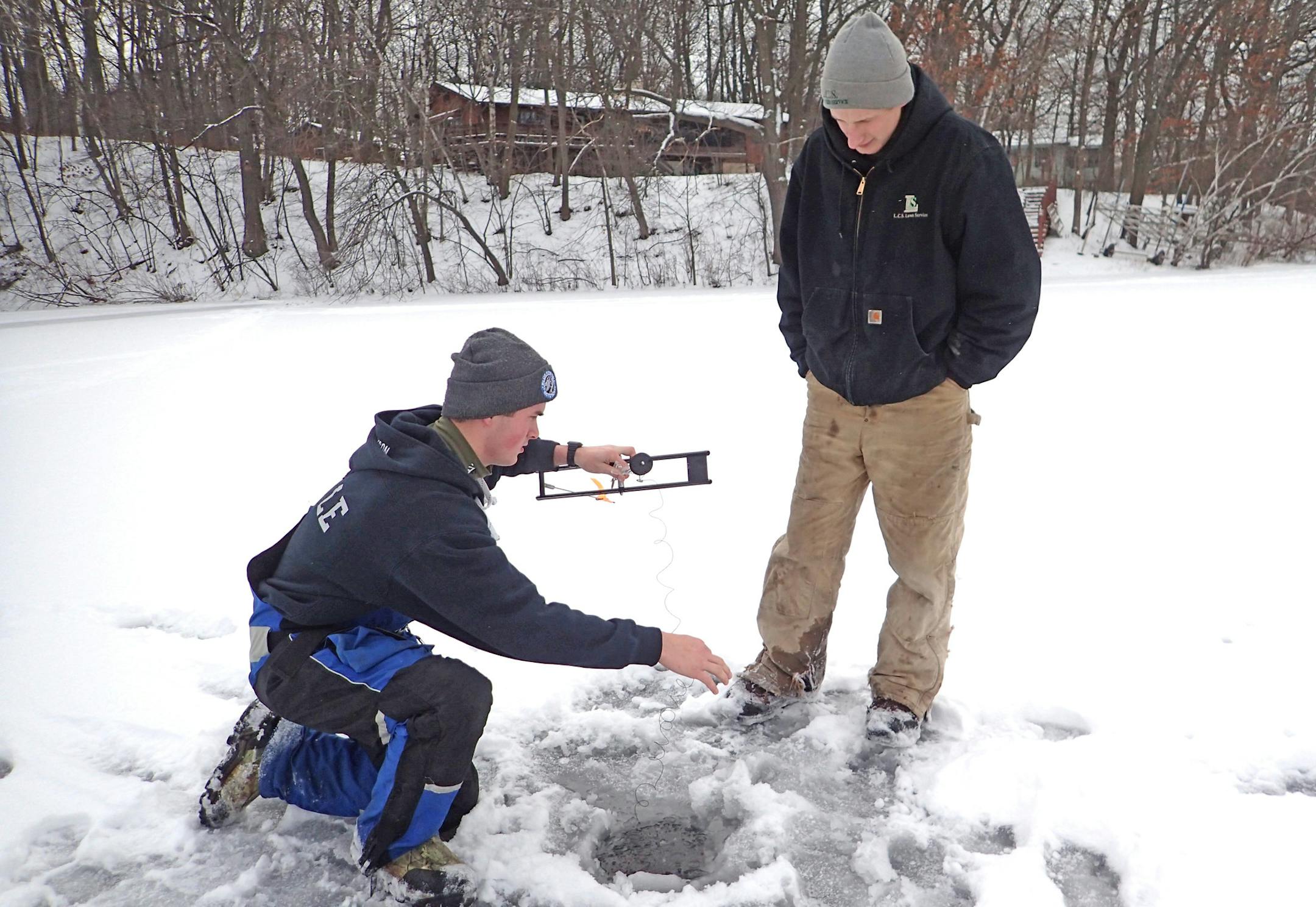 Jake Erickson, left, of Oakdale checked a tip-up, hoping a northern pike would be hooked, while Justin Meyer of Maplewood watched. They were fishing on Lake Demontreville.