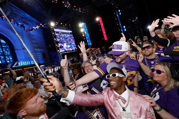 First-round pick Jordan Addison poses with Vikings fans after being drafted.