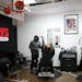 Barber Akeem Akway watches as Hopkins basketball standout Anthony Smith Jr. scores mid-haircut at Akway's Sports Barbershop in Eagan.