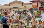 A man paused March 25 at a makeshift memorial outside King Soopers grocery store in Boulder, Colo., to those killed in mass shooting at the store the 