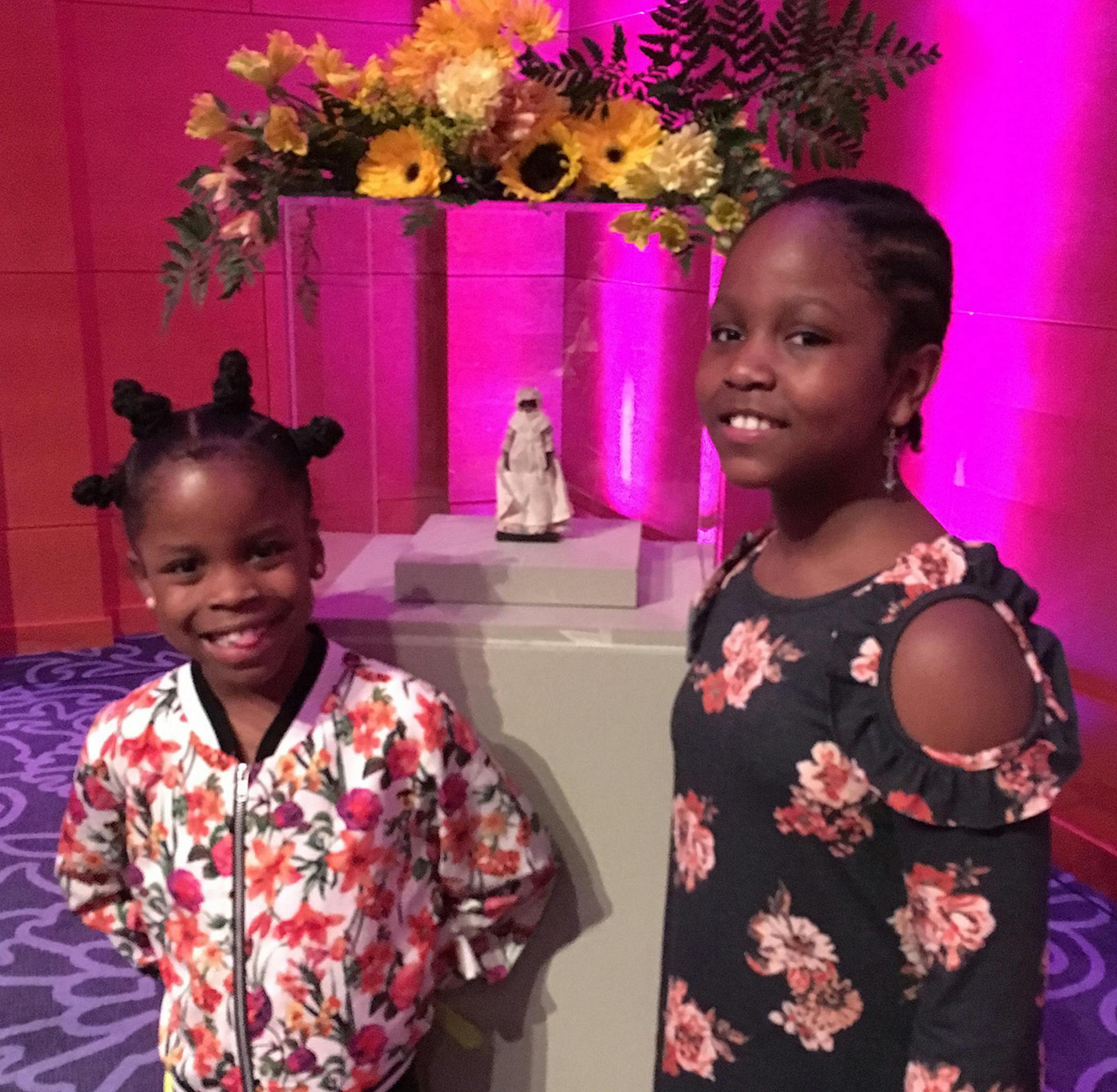 Gail Rosenblum From left" Josephine Anderson, 8, and Millicent Anderson, 9, are daughters of Andrea Pierre. They're standing in from of the doll that was removed from the dollhouse.