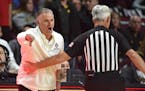 San Diego State coach Brian Dutcher is held back by a referee as he calls to his team during the first half against Iowa on Nov. 29