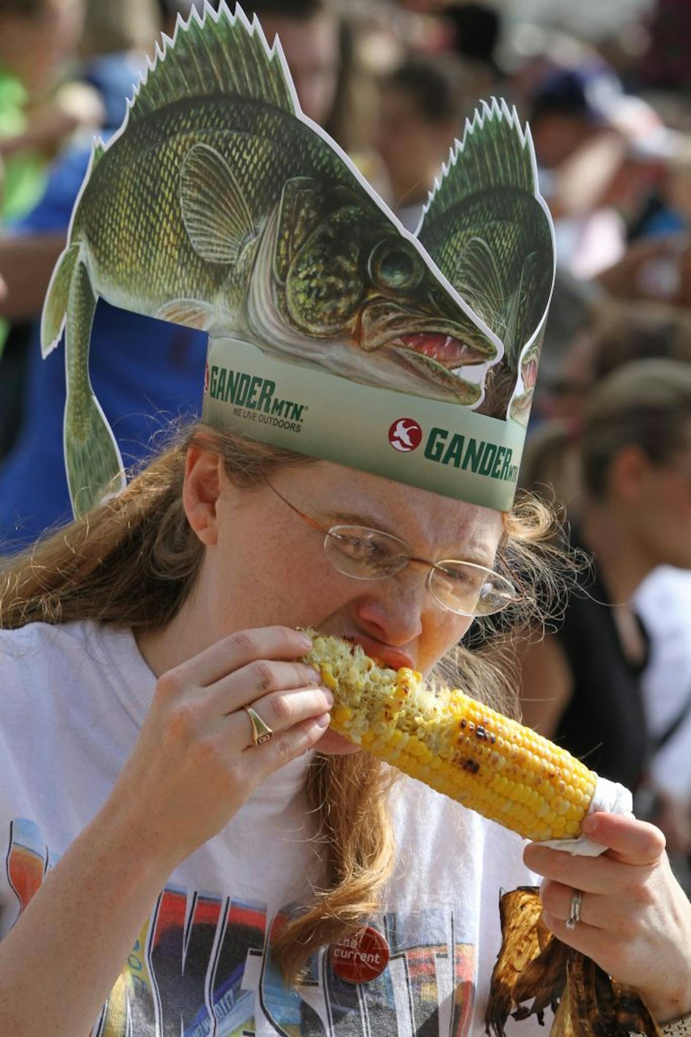 Greta Wegner of Falcon Heights had a fish on her head and a freshly roasted ear of Ribar's corn in her hand at the State Fair.