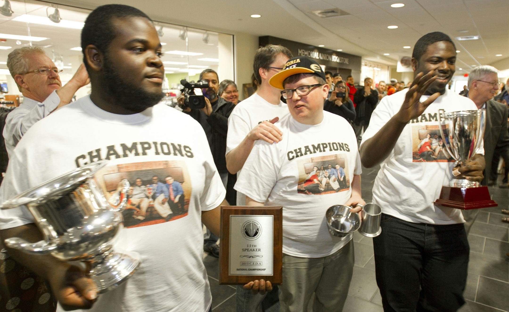 From left, Elijah Smith, Chris Loghry, assistant debate director, Sam Maurer, debate director, and Ryan Wash, pause to wave at the crowd during a student parade to celebrate two national debate titles won over the past week by Wash and Smith, at Emporia State University on Wednesday, April 3, 2013, in Emporia, Kansas. (Shane Keyser/Kansas City Star/MCT)