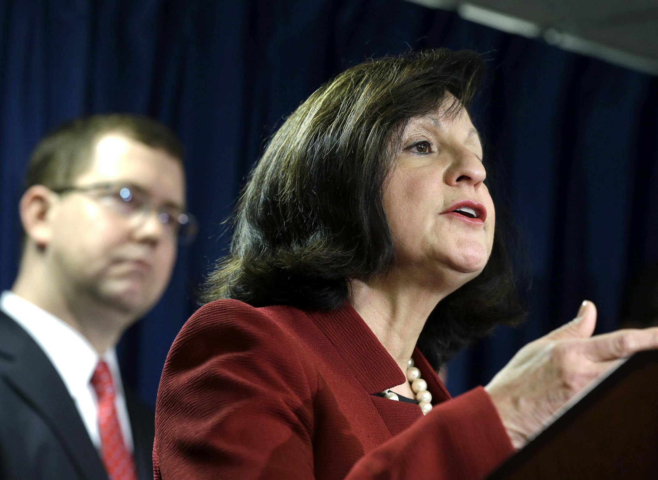 United States Attorney Carmen Ortiz announces indictments of 14 owners and employees from the New England Compounding Center Wednesday, Dec. 17, 2014, in Boston. More than 750 people in 20 states were sickened, and 64 died after they contracted fungal meningitis and other illnesses in 2012 from tainted steroids made by the Framingham, Mass., company. At left is Associate Attorney General Stuart Delery. (AP Photo/Steven Senne)