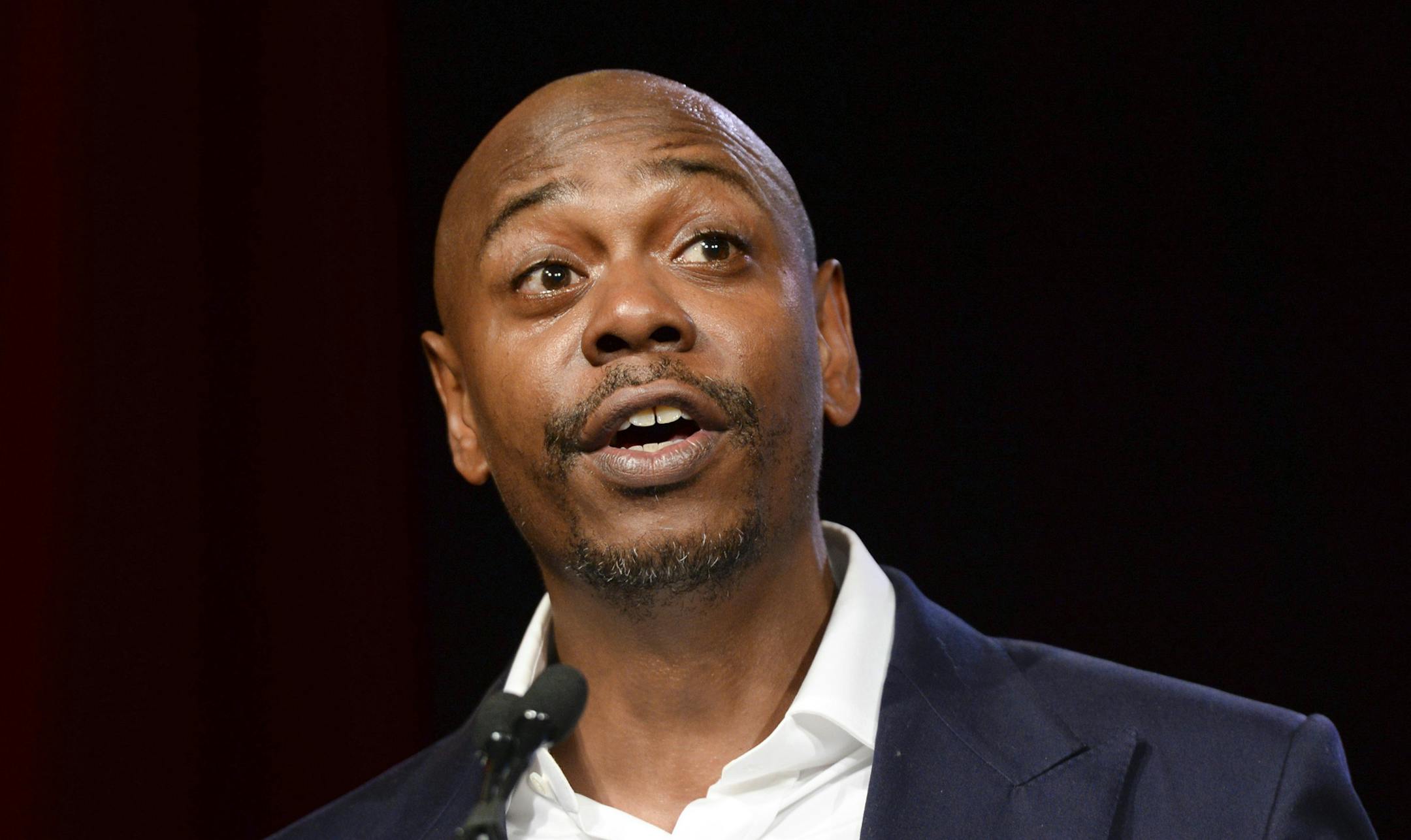 FILE - In this July 18, 2015 file photo, comedian Dave Chappelle speaks at the RUSH Philanthropic Arts Foundation's Art for Life Benefit in New York. Chappelle is set to host NBCís ìSaturday Night Liveî on Nov. 12, marking his debut appearance on the show. He will be joined by hip-hop group A Tribe Called Quest. (Photo by Scott Roth/Invision/AP, File)