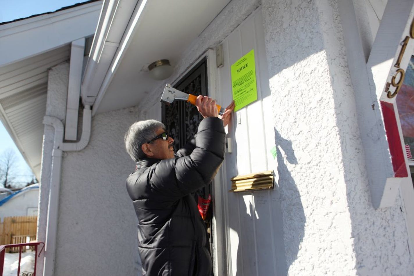 Minneapolis housing inspector Farrokh Azmoudeh posted a notice on a boarded up north Minneapolis house in 2010. The Minnesota Supreme Court will arguments this week on whether landlords and tenants can block routine city housing inspections.