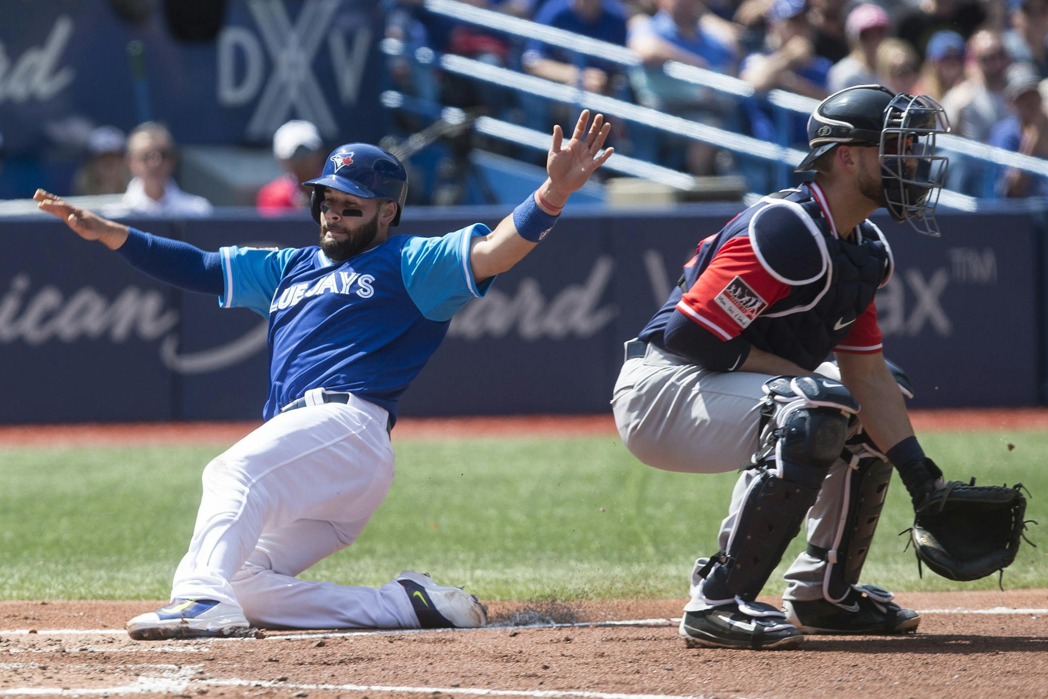 Toronto Blue Jays' Raffy Lopez, left, scores on a sacrifice fly in front of Minnesota Twins catcher Mitch Garver during third inning American League MLB baseball action in Toronto on Saturday, Aug. 26 2017. (Chris Young/The Canadian Press via AP)