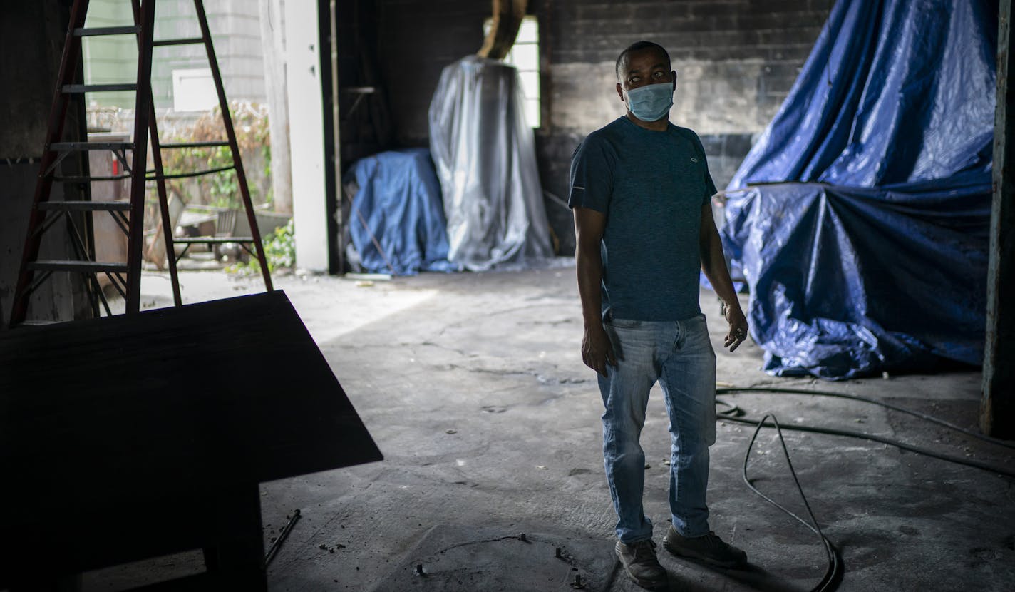 Gemechis Merga stood in the damaged remains of Rongo's Auto Repair in Minneapolis. His insurer will cover a fraction of damages incurred in the riots.