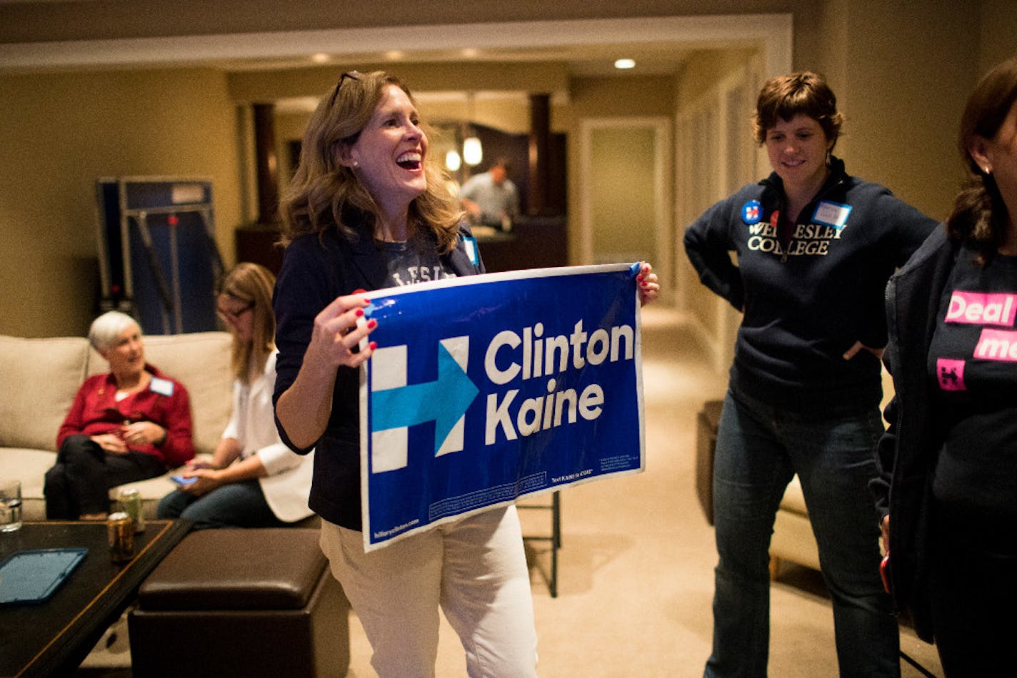 Sara Pearce holds a sign from a guest during an election party for Wellesley College alumni supporting Democratic presidential candidate Hillary Clinton at the home of Sara and Nick Pearce on Tuesday, Nov. 8, 2016, in Edina.