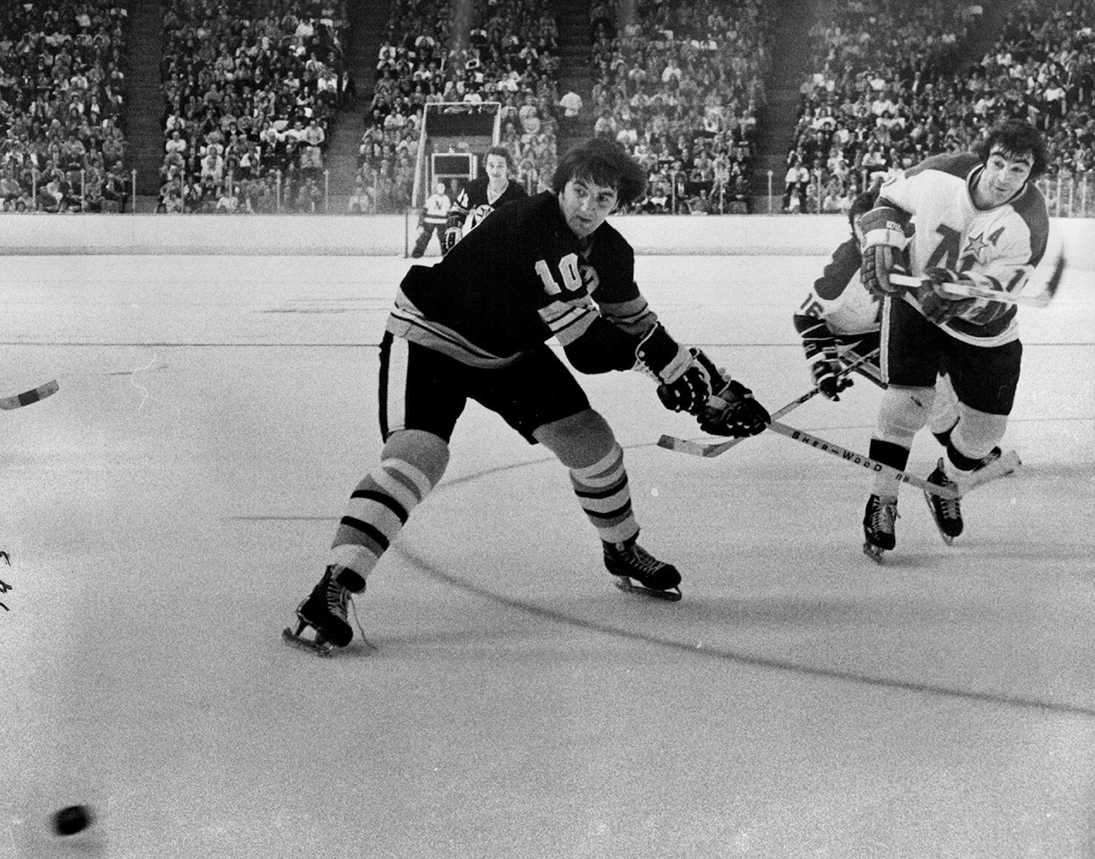 Parise scored against Boston in 1974. The Bruins player is Carol Vadnais.