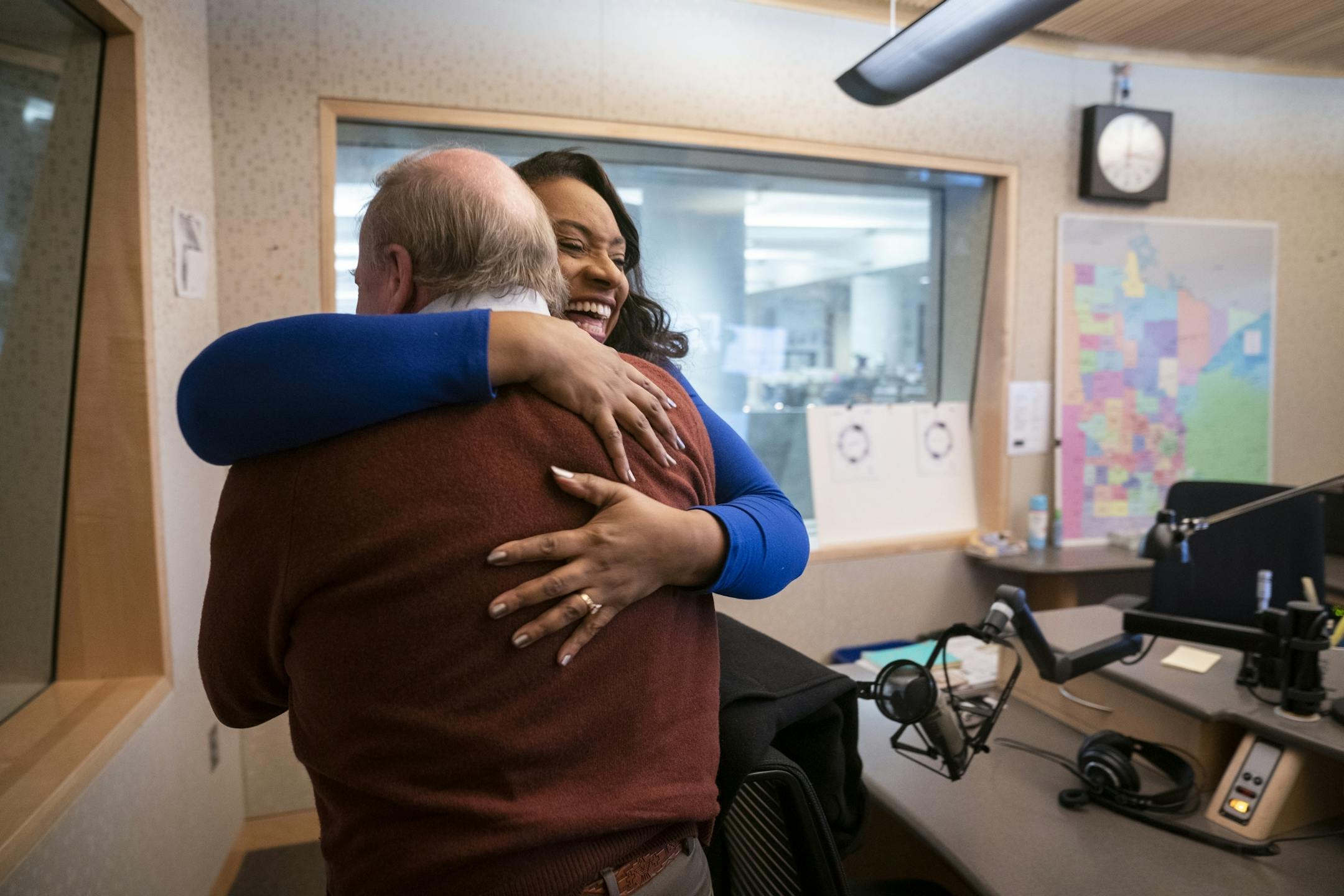 MPR host Angela Davis hugs guest Joe Mansky, the current Ramsey County elections manager who is retiring, after interviewing him on her show.