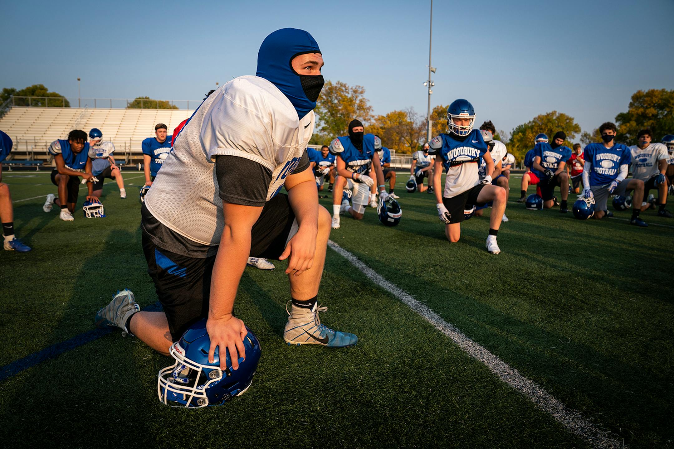 Center Jake Raines listened during a socially-distanced huddle at Woodbury High School football practice.