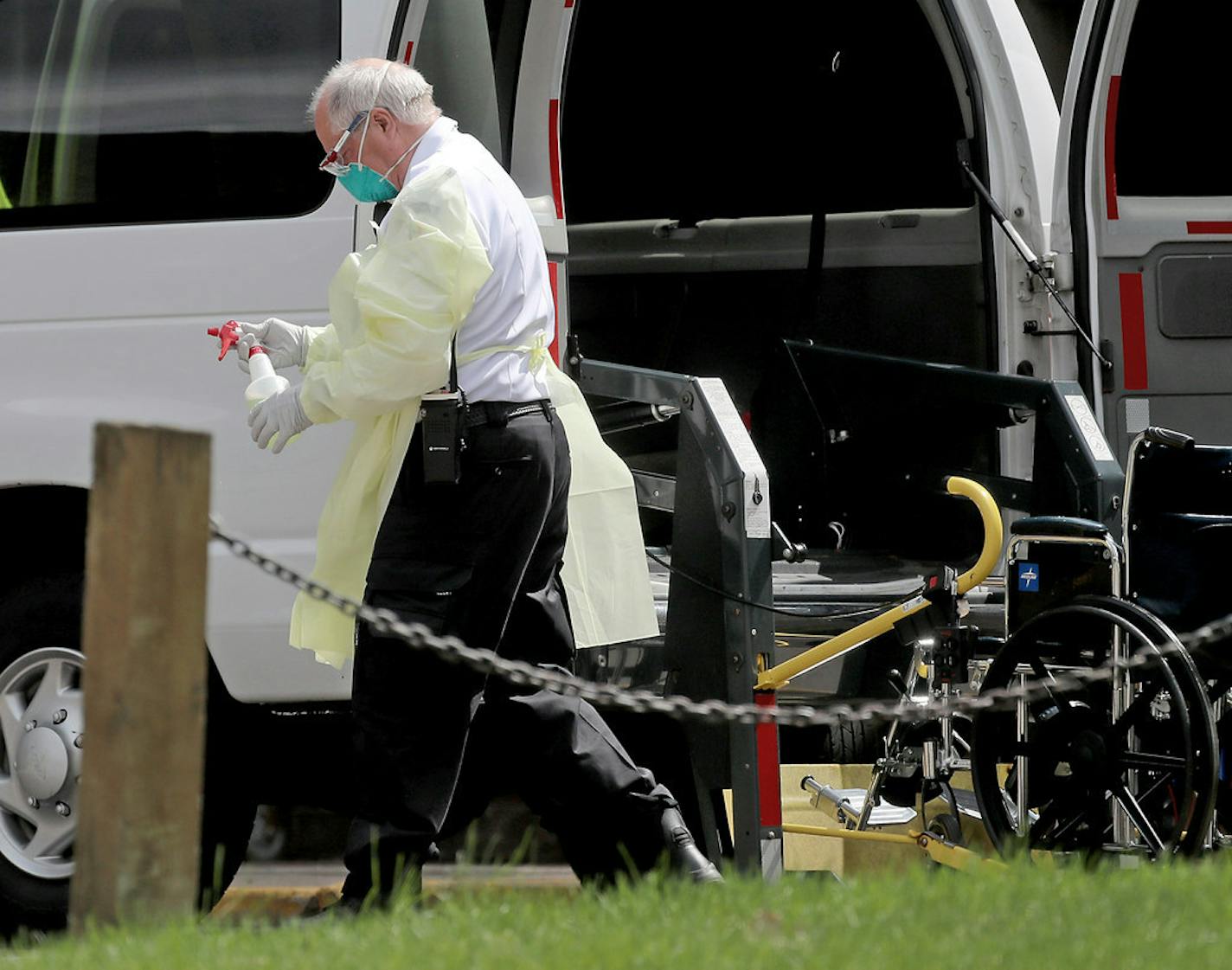 A hospital worker holds a bottle of disinfectant outside the North Ridge Health and Rehab nursing home in New Hope, Minn. The nursing home which has a history of regulatory problems, recently evicted two residents for violating its policy against leaving the facility without approval.