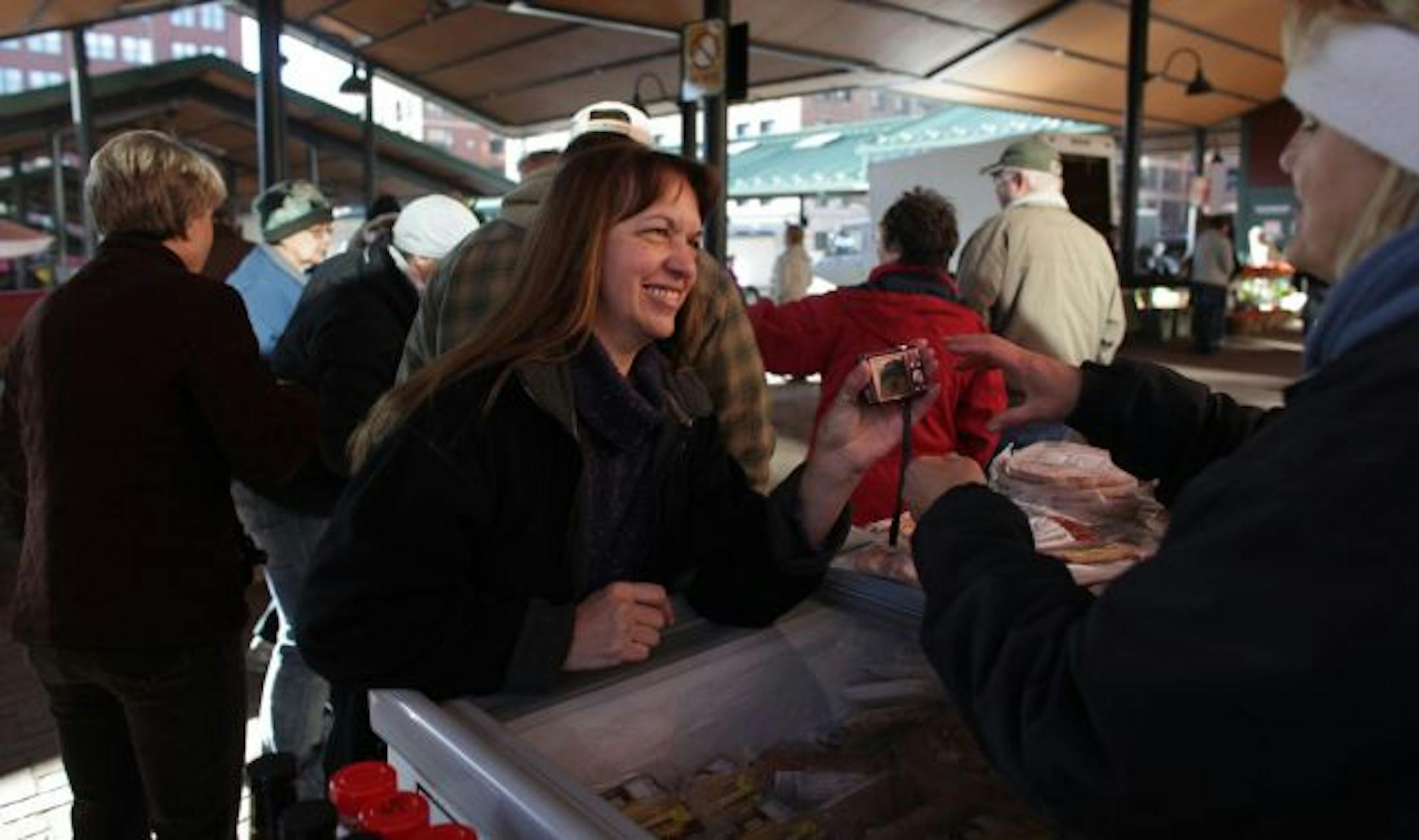 Regular Ana Houghton, of St. Paul, showed off her new grandson to Dawn Hubmer owner and operator of Prairie Pride Farm at the St. Paul farmers market.